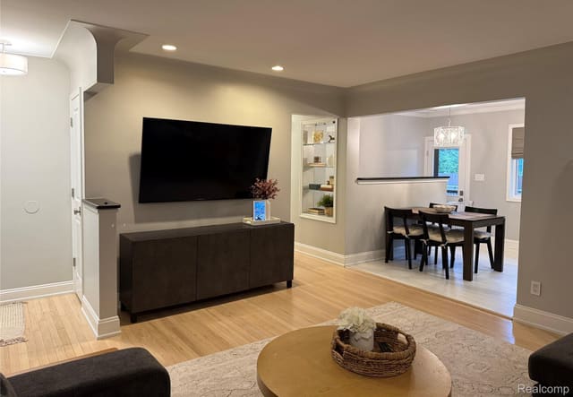 Living room with mounted TV open to the dining area