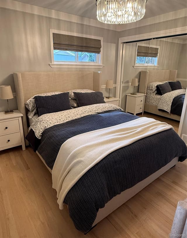Primary bedroom with upholstered bed and hardwood floor