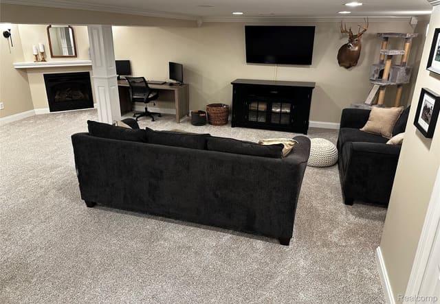 Basement media area with fireplace and mounted TV