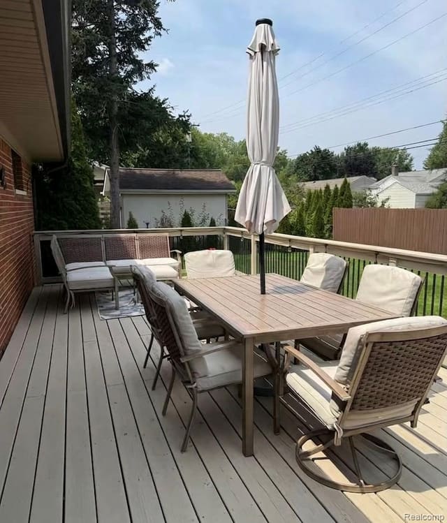Composite deck with umbrella dining set overlooking the fenced backyard