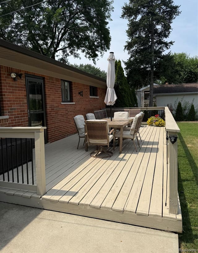 Rear deck along the brick exterior with outdoor dining